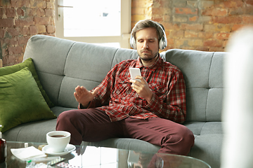 Image showing Caucasian man staying at home during quarantine because of coronavirus spreading