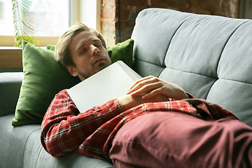 Image showing Caucasian man staying at home during quarantine because of coronavirus spreading