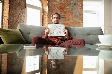 Image showing Caucasian man staying at home during quarantine because of coronavirus spreading