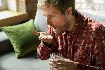 Image showing Caucasian man staying at home during quarantine because of coronavirus spreading