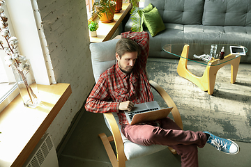 Image showing Caucasian man staying at home during quarantine because of coronavirus spreading