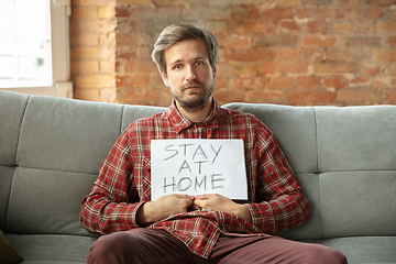 Image showing Caucasian man staying at home during quarantine because of coronavirus spreading