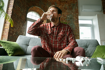 Image showing Caucasian man staying at home during quarantine because of coronavirus spreading