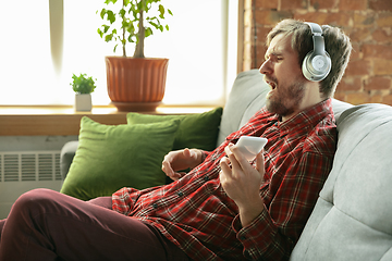 Image showing Caucasian man staying at home during quarantine because of coronavirus spreading