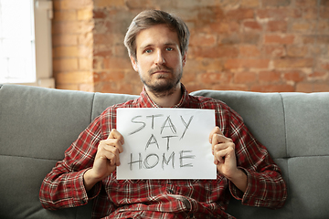 Image showing Caucasian man staying at home during quarantine because of coronavirus spreading
