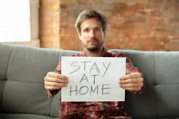 Image showing Caucasian man staying at home during quarantine because of coronavirus spreading