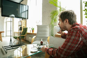 Image showing Caucasian man staying at home during quarantine because of coronavirus spreading