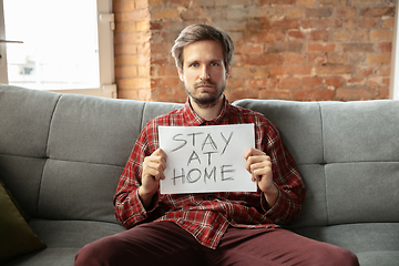 Image showing Caucasian man staying at home during quarantine because of coronavirus spreading