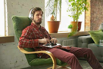 Image showing Caucasian man staying at home during quarantine because of coronavirus spreading