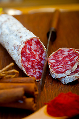 Image showing traditional Italian salame cured sausage sliced on a wood board