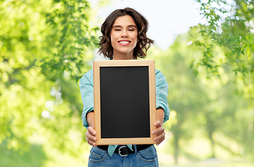 Image showing portrait of smiling woman showing black chalkboard