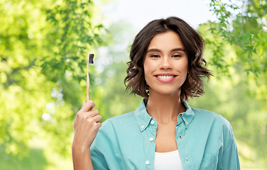 Image showing smiling young woman with wooden toothbrush