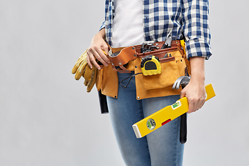 Image showing woman builder with level and working tools on belt