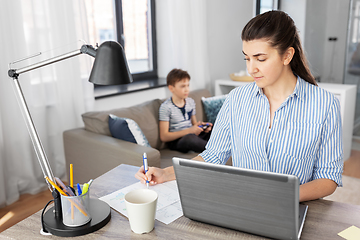 Image showing working mother and son playing video game at home