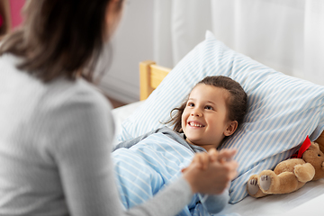 Image showing mother and happy little daughter in bed at home