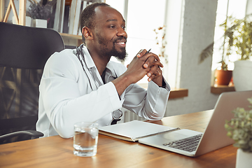 Image showing African-american doctor consulting for patient, working in cabinet, close up