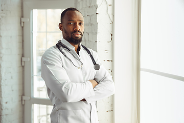 Image showing African-american doctor consulting, working in cabinet, close up