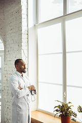 Image showing African-american doctor consulting, working in cabinet, close up