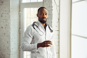 Image showing African-american doctor consulting, working in cabinet, close up