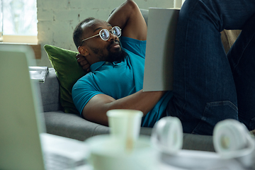 Image showing African-american man staying at home during quarantine because of coronavirus spreading