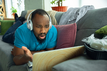 Image showing African-american man staying at home during quarantine because of coronavirus spreading