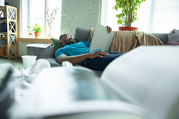 Image showing African-american man staying at home during quarantine because of coronavirus spreading