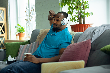 Image showing African-american man staying at home during quarantine because of coronavirus spreading