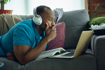 Image showing African-american man staying at home during quarantine because of coronavirus spreading