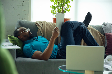 Image showing African-american man staying at home during quarantine because of coronavirus spreading