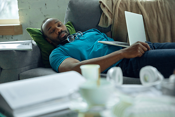 Image showing African-american man staying at home during quarantine because of coronavirus spreading