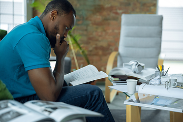 Image showing African-american man staying at home during quarantine because of coronavirus spreading