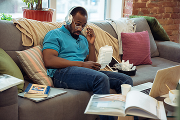 Image showing African-american man staying at home during quarantine because of coronavirus spreading