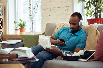 Image showing African-american man staying at home during quarantine because of coronavirus spreading