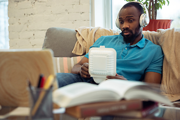 Image showing African-american man staying at home during quarantine because of coronavirus spreading