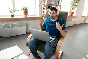 Image showing Young focused man studying at home during online courses or free information by hisself