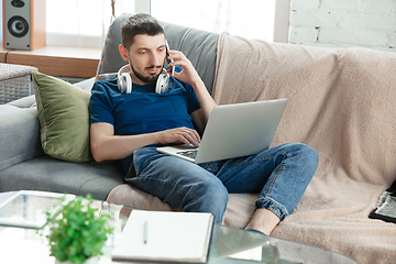 Image showing Young focused man studying at home during online courses or free information by hisself