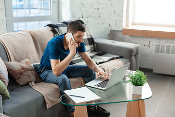 Image showing Young focused man studying at home during online courses or free information by hisself