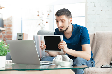 Image showing Young focused man studying at home during online courses or free information by hisself