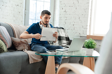 Image showing Young focused man studying at home during online courses or free information by hisself