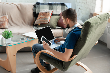 Image showing Young focused man studying at home during online courses or free information by hisself