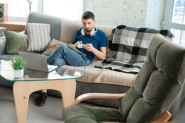 Image showing Young focused man studying at home during online courses or free information by hisself