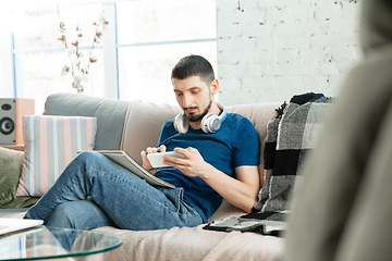 Image showing Young focused man studying at home during online courses or free information by hisself