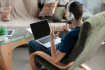 Image showing Young focused man studying at home during online courses or free information by hisself