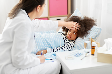 Image showing doctor with clipboard and sick girl in bed at home