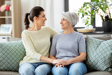 Image showing senior mother with adult daughter hugging at home