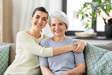 Image showing senior mother with adult daughter hugging at home