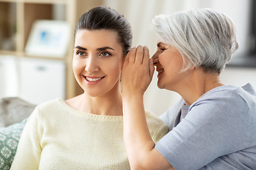 Image showing senior mother whispering secret to adult daughter