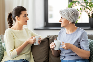 Image showing senior mother and adult daughter drinking coffee