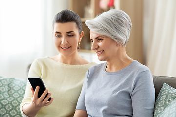 Image showing daughter and senior mother with smartphone at home