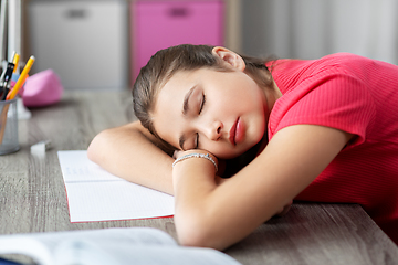 Image showing tired student girl sleeping on table at home